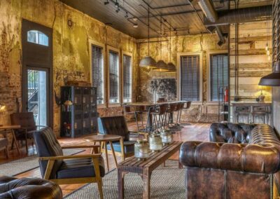 An open lounge space with a mix of industrial and vintage decor, featuring leather couches and wood accents.