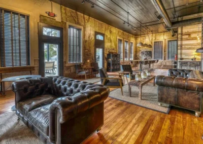 An open lounge space with a mix of industrial and vintage decor, featuring leather couches and wood accents.