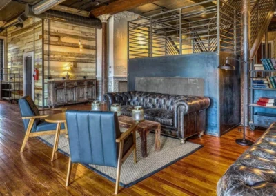 An open lounge space with a mix of industrial and vintage decor, featuring leather couches and wood accents.